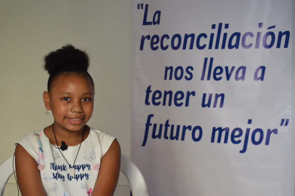 Susana Caicedo junto a un pendón de la Pastoral Afro