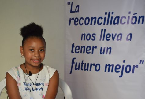 Susana Caicedo junto a un pendón de la Pastoral Afro