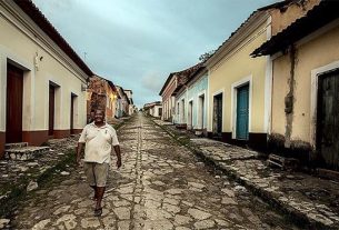 Quilombola camina por calle empedrada y solitaria en Brasil.