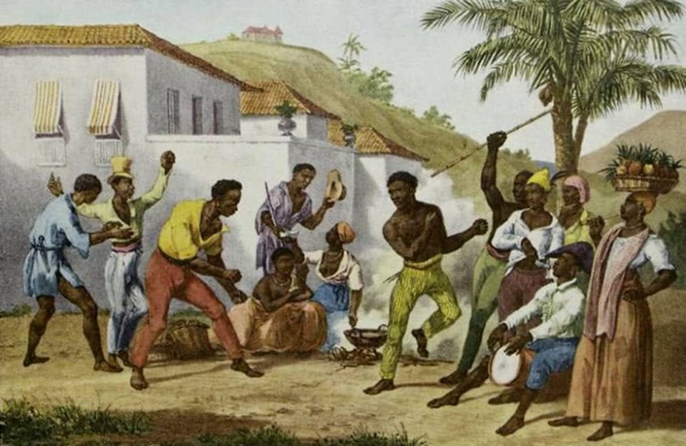 Grabado a color de una danza-lucha entre hombres afro. Hombres y mujeres negros les rodean, los varones celebran, las mujeres observan, una de ellas con un platón lleno de frutas. Un hombre con gorro napoleónico toca sentado el tambor y una mujer conversa mientras cocina en un fogón humeante. Al fondo se ven casas coloniales y el cerro de La Popa.