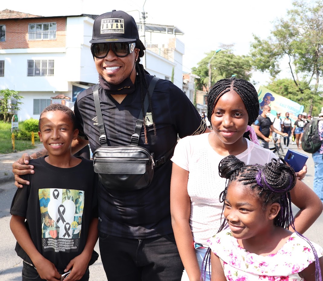 Junior Jein aparece en la calle, gafas y ropas oscuras mientras abraza un niño y una niña afro, mientras otra cerca sonríe a otra cámara. Jein viste una gorra negra con el letrero -Ahora no vaya a escandalizarse-El niño también lleva una camisa negra con los rostros de los jóvenes asesinados en Llano Verde con lazos negros. Al fondo se ve una manifestación.